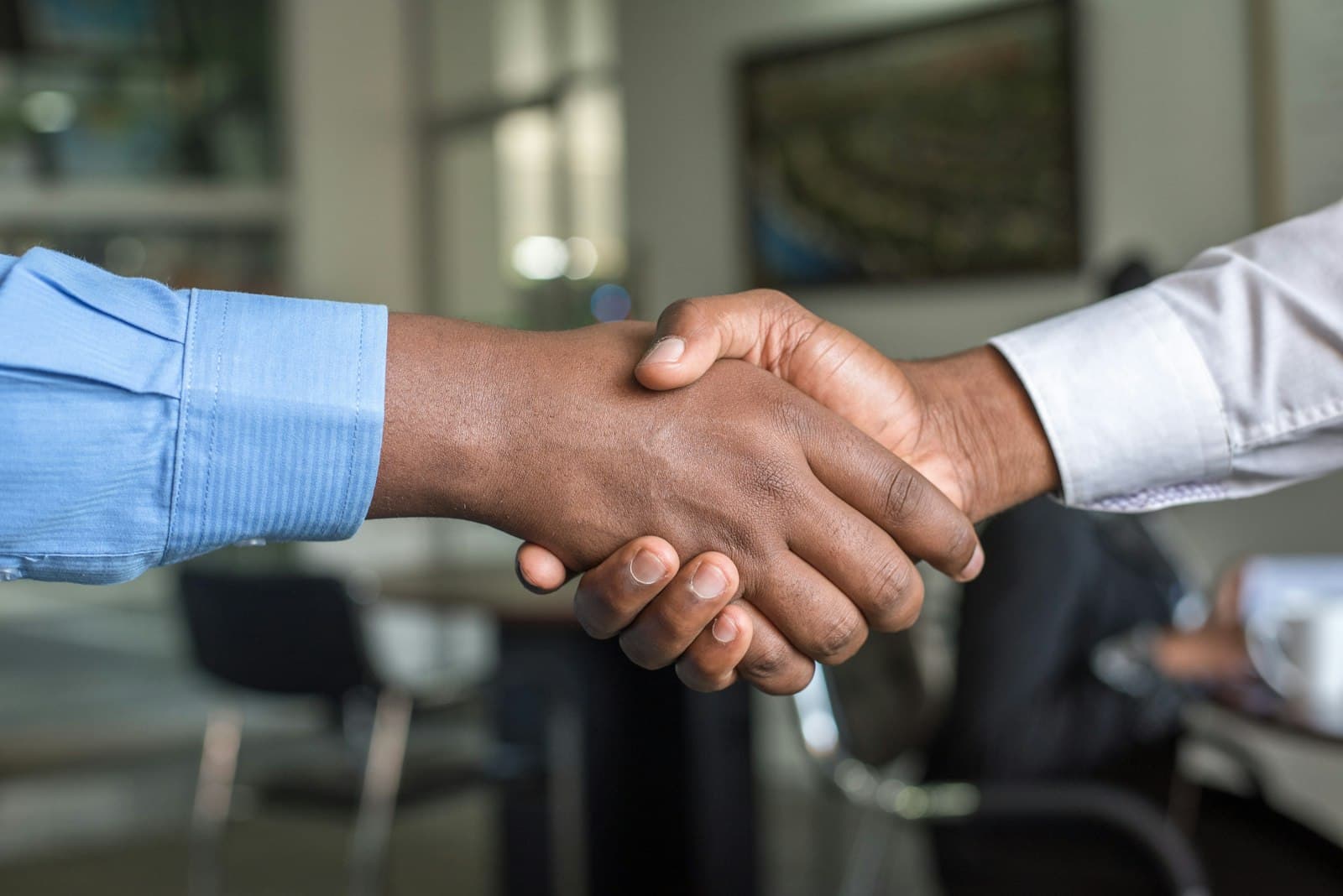 Two people shaking hands in a meeting